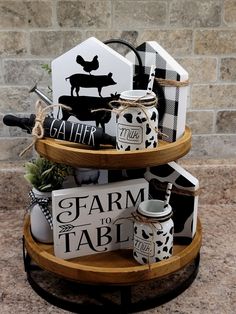 three tiered display with farm to table signs on it's sides and black and white decorations