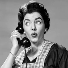 a woman holding a telephone up to her ear and making a surprised face as she talks on the phone