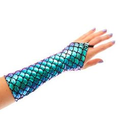 a woman's hand with blue and green mermaid scales on it, holding out her arm