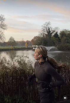 a woman is jogging by the water with ear buds in her ears