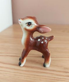 a small deer figurine sitting on top of a wooden table