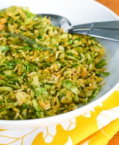 a white bowl filled with broccoli sprouts on top of a table