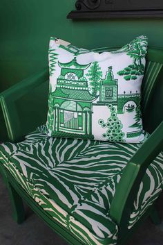 a green and white chair with a pillow on it