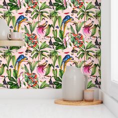 a pink wallpaper with tropical birds and flowers on it, next to two vases