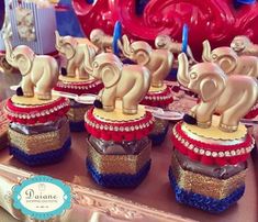 there are many little elephants on top of small cakes in the shape of elephants with red, white and blue ribbons