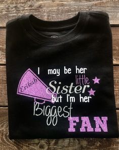 Custom I May Be Her Little Sister but I Am her Biggest Fan shirt with megaphone. Great for siblings to wear to competitions to show their support and stand out from the crowd. Can be customized for your team colors. Will be made with glitter colors unless other wise stated If you have a custom idea, please let us know. We would love to bring your idea to life. Cheer Sister Shirts Ideas, Cheer Sister Shirts, Cheer Sister Shirts Designs, Baby Sister Cheer Shirts, Black Fan Apparel T-shirt For Cheerleading, Cheerleading Fan Apparel T-shirt With Custom Print, Sassy Cheer Mom Shirt, I Am Her, Cheer Shirt