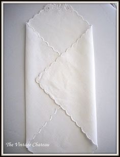 a white napkin with scalloped edges on top of it, sitting on a table