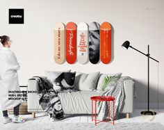 a woman standing in front of a couch with skateboards on the wall