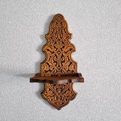 an ornate wooden shelf on the wall