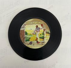 a black record with an image of a man holding a baseball bat on it's side