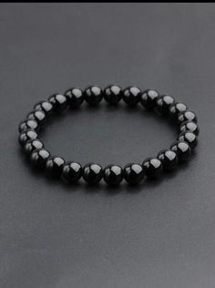 This black pearl bracelet is an elegant and timeless accessory for men. It is made of smooth and shiny black beads which are connected by an elastic thread. This bracelet is perfect for completing a casual or formal look and adding a touch of sophistication to your style. Mens Bracelet Beads, Black Pearl Bracelet, Elastic Thread, Men's Bracelet, Mens Beaded Bracelets, Timeless Accessories, Formal Looks, Black Pearl, Black Beads