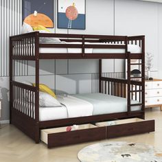 a bunk bed with drawers underneath it in a room that has white walls and wooden floors