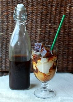 an iced drink in a glass next to a bottle