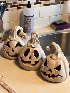 three ceramic pumpkins sitting on top of a kitchen counter