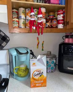 the elf on the shelf is hanging from the wall above the coffee maker and other items