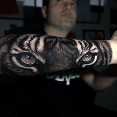 a man is showing off his arm with an animal's face painted on it