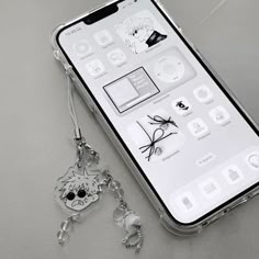 an iphone with a key chain attached to it's back cover and various app icons displayed on the screen