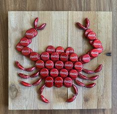 a crab made out of coca - cola bottle caps sitting on top of a wooden table