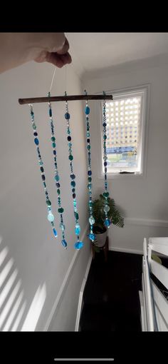 a hand is holding a long beaded curtain with beads hanging from it's end