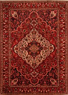 a red rug with an intricate design on the center and sides, in different colors