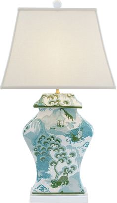 a blue and white vase with a lamp on top