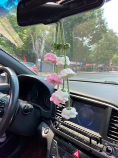 the interior of a car with pink and white flowers hanging from it's dash board