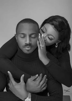 a man and woman hugging each other with their hands on the chest, black and white photo