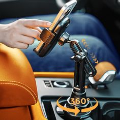 a person holding a cell phone in their hand while sitting on a car steering wheel