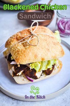 a sandwich with meat, lettuce and onions on it sitting on a plate