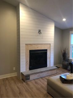 an empty living room with a fireplace and couch