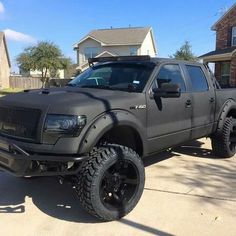 a black truck parked in front of a house