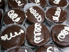 chocolate cupcakes with white frosting and the word love spelled in cursive writing