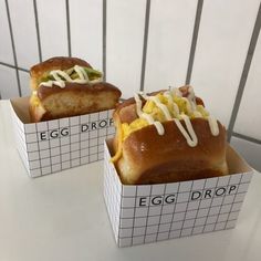 two egg drop sandwiches sitting on top of a white table