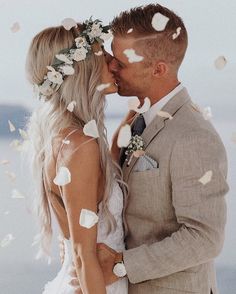 a bride and groom kissing in front of confetti falling from their foreheads