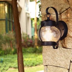 a light that is on the side of a stone wall in front of a house