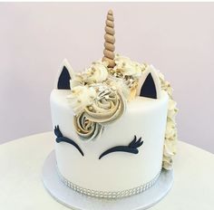 a white cake decorated with an unicorn's horn and flowers