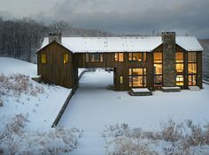 a house in the middle of a snowy field