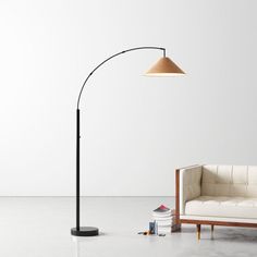 a white couch sitting next to a black lamp on top of a wooden table in a living room