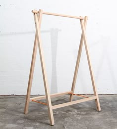 a wooden easel leaning against a white wall