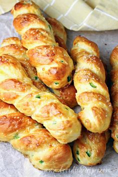 several pieces of bread with cheese and herbs on them sitting next to a baguette