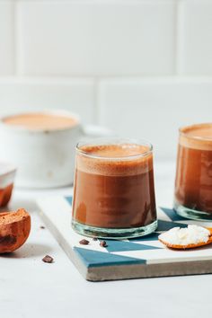 two glasses of hot chocolate on a cutting board