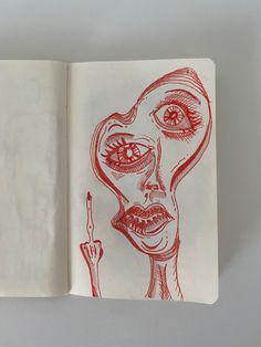 an open notebook with a drawing of a woman's face and eyeballs on it