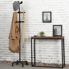 a white brick wall with a coat rack, mirror and hat on it's stand