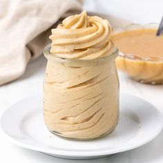 a jar filled with peanut butter sitting on top of a white plate