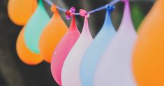 colorful balloons are hanging from a string