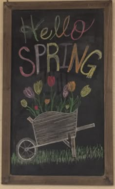 a chalkboard with flowers in a wheelbarrow and the words hello spring written on it