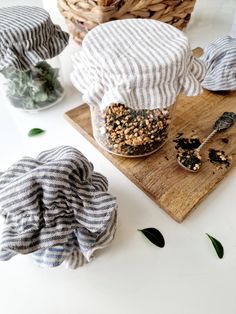 three jars filled with food sitting on top of a wooden cutting board