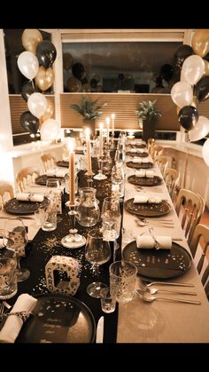 a long table set with plates, silverware and candles for an elegant dinner party