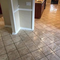 an empty kitchen with tile flooring and white trim on the walls in front of it