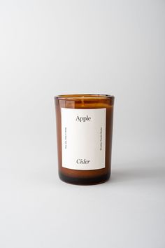 an apple candle sitting on top of a white table